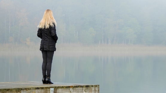 Woman standing in front of a lake