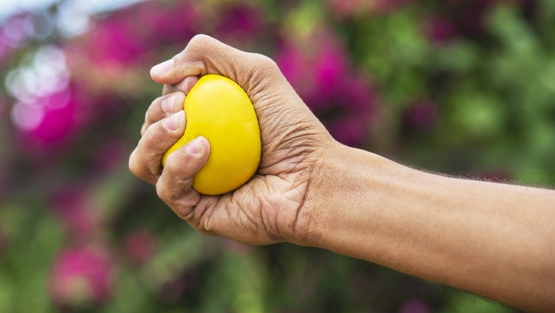 hand holding yellow stress ball