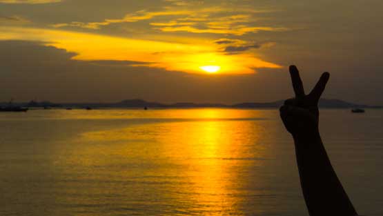Sunset with a peace sign hand