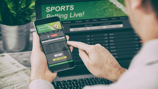 Man with a cellphone looking at sports betting