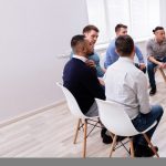 Young Multiracial Millennial Friends Sitting In Circle Having Group Discussion