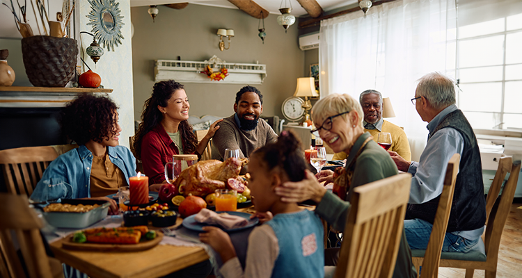 Happy family sits around the table in holiday cheer.