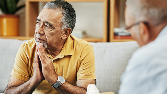 A man sits looking out, he's sad & contemplative.