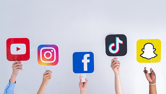 Hands holding up social media icons.