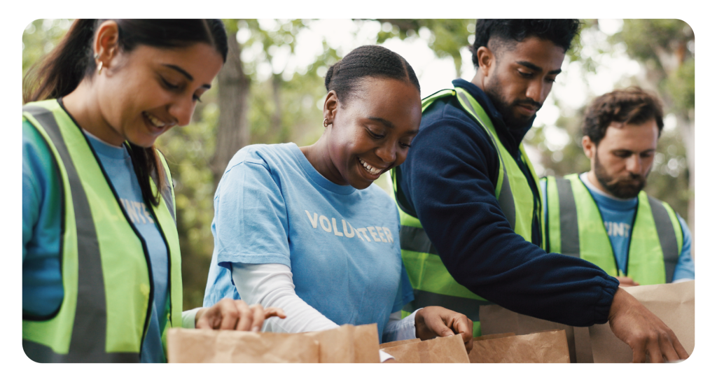 Outdoor, volunteers and group with donations, charity or happy for community service with food boxes. Humanitarian, people and team with supply distribution, NGO and social responsibility in woods.